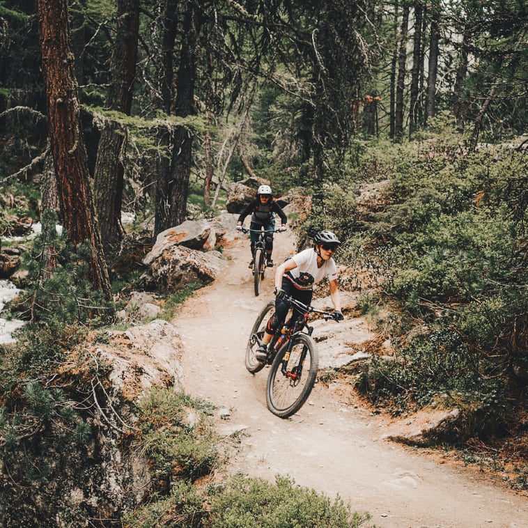 due ciclisti in mountain bike su un sentiero vicino al fiume